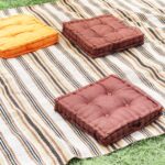 A high angle shot of pillows on a blanket ready for a picnic